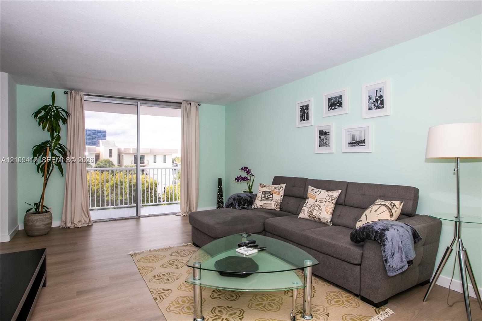 Living area featuring wood-finish flooring and sliding glass doors with access to an exterior balcony