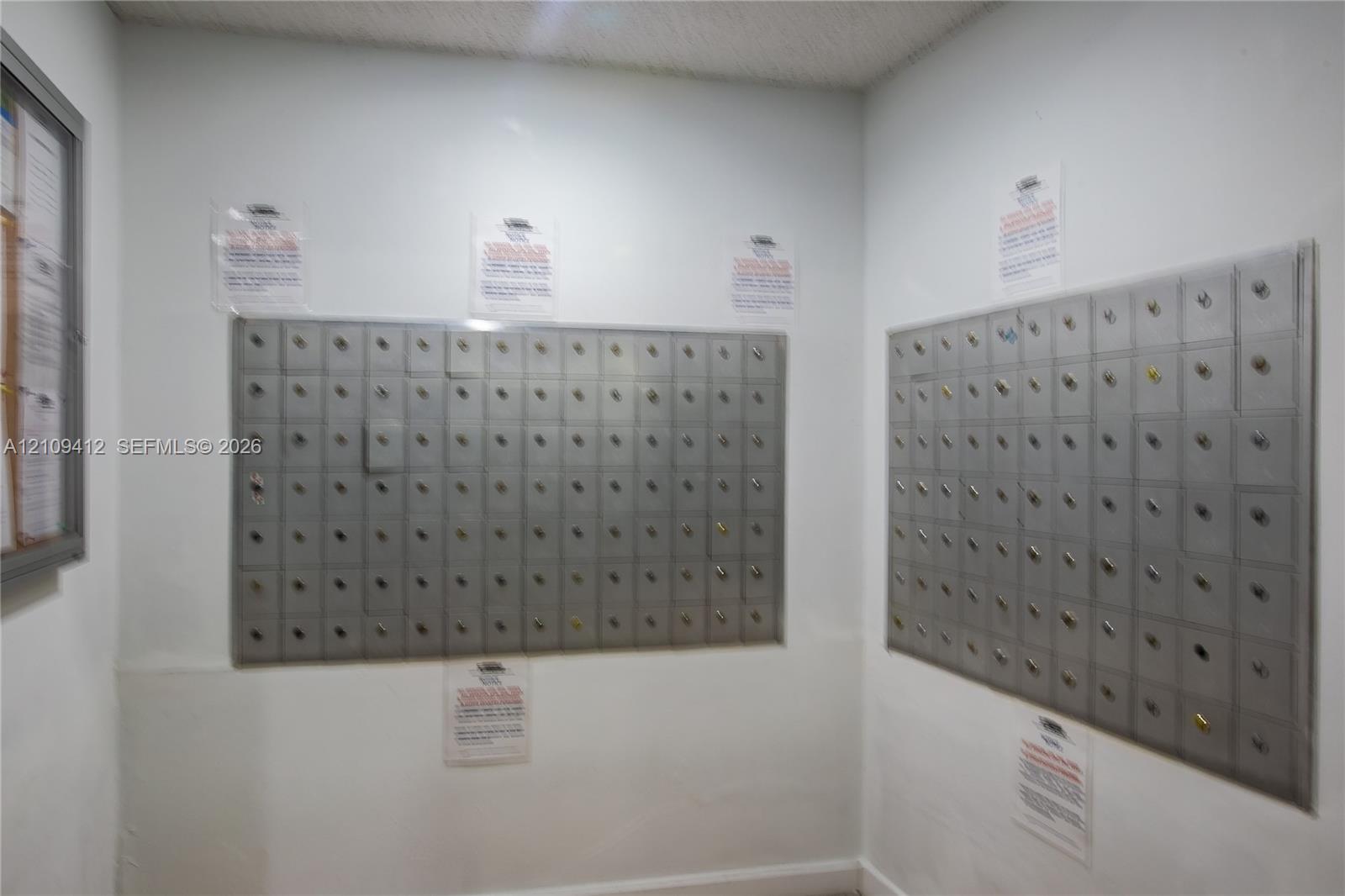 Dedicated mailroom featuring dual wall-mounted, multi-compartment metal postal banks with integrated key locks