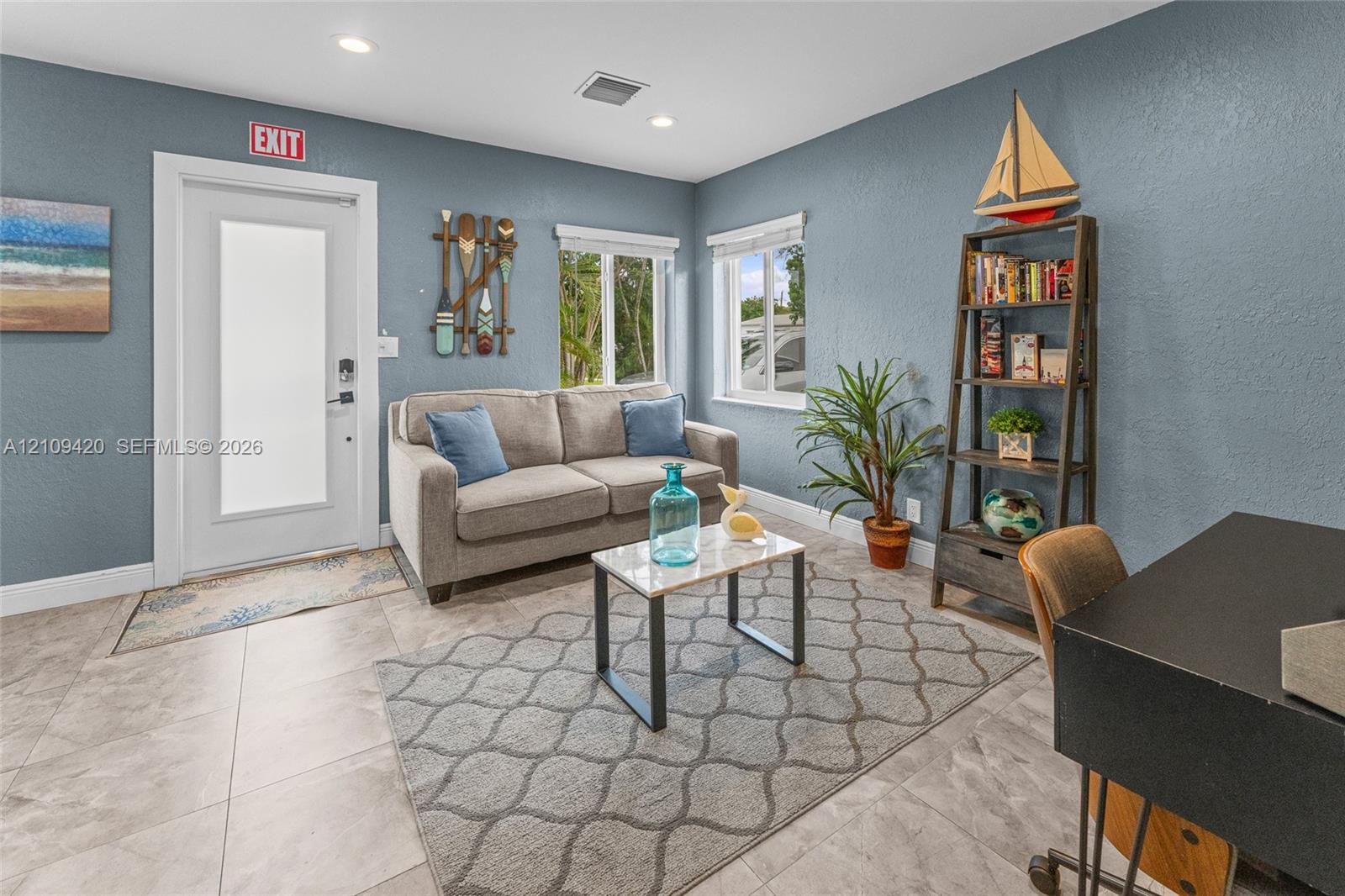 Neutral-toned ceramic tile flooring, recessed ceiling lighting, textured walls, and multi-pane windows