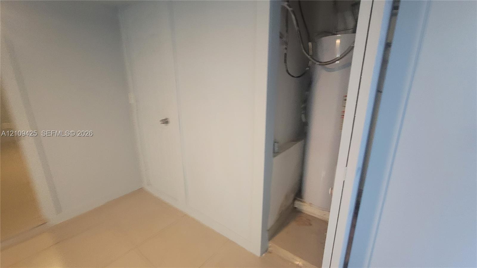 Mechanical space featuring a water heater and solid-core interior door