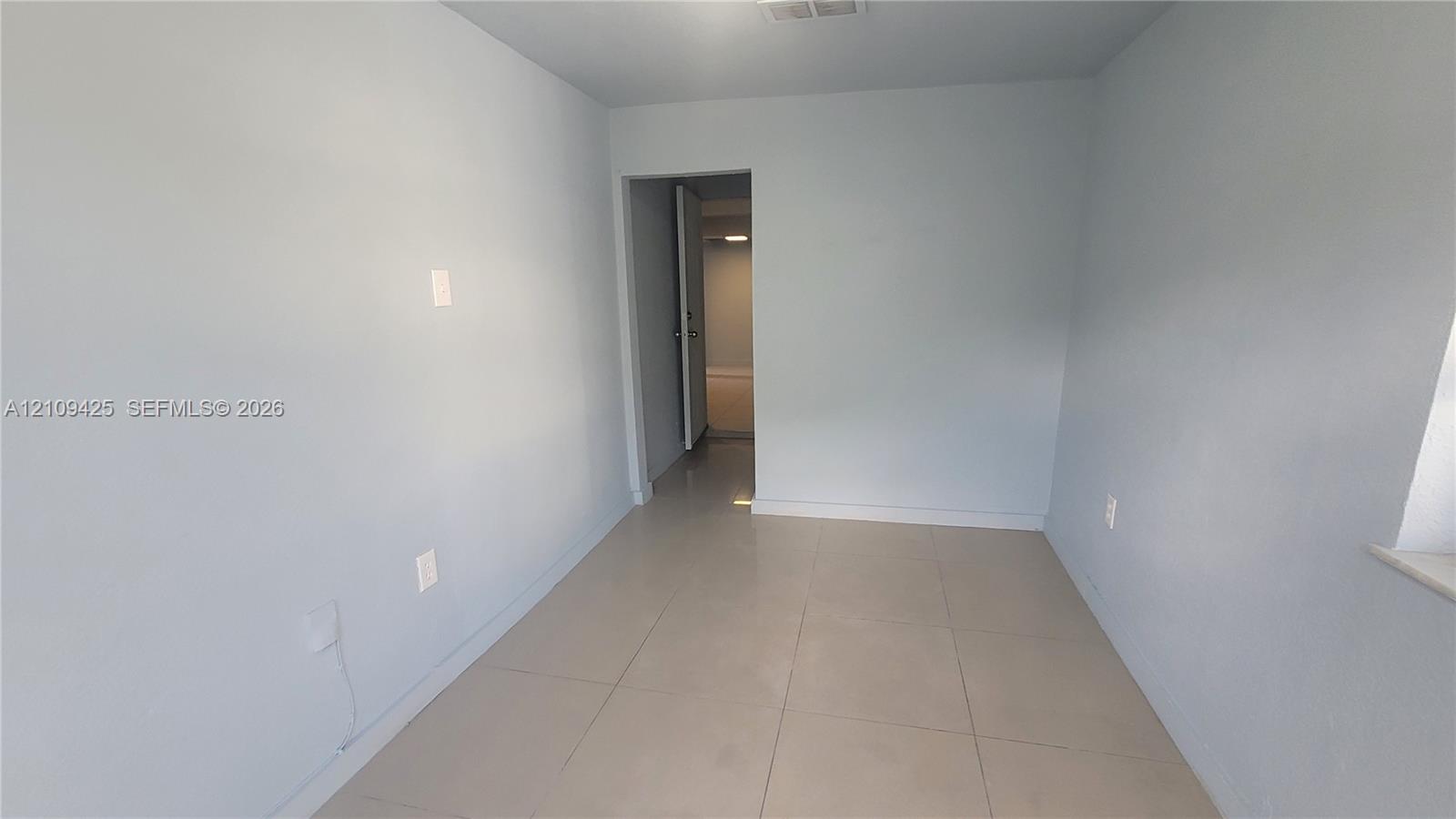 Neutral-toned wall finish with large-format ceramic tile flooring