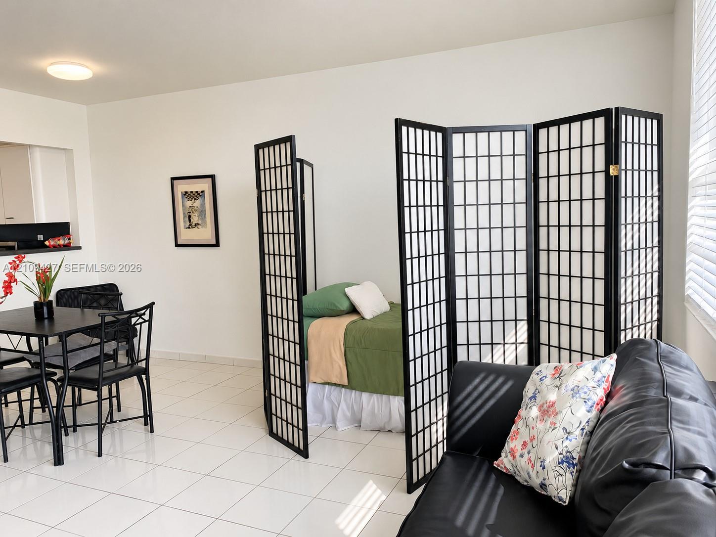 Neutral-toned ceramic tile flooring, clean white wall finishes, and horizontal window blinds
