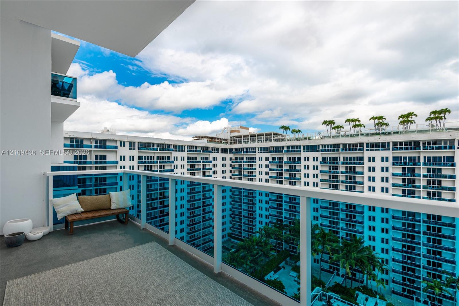 Private balcony featuring a glass-panel railing and concrete flooring
