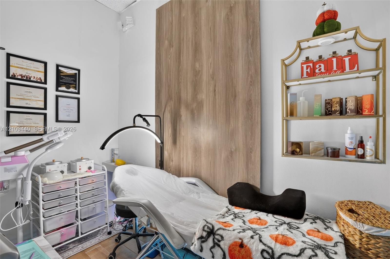 Wall-mounted metal shelving unit with glass tiers and a floor-to-ceiling wood-finish accent panel