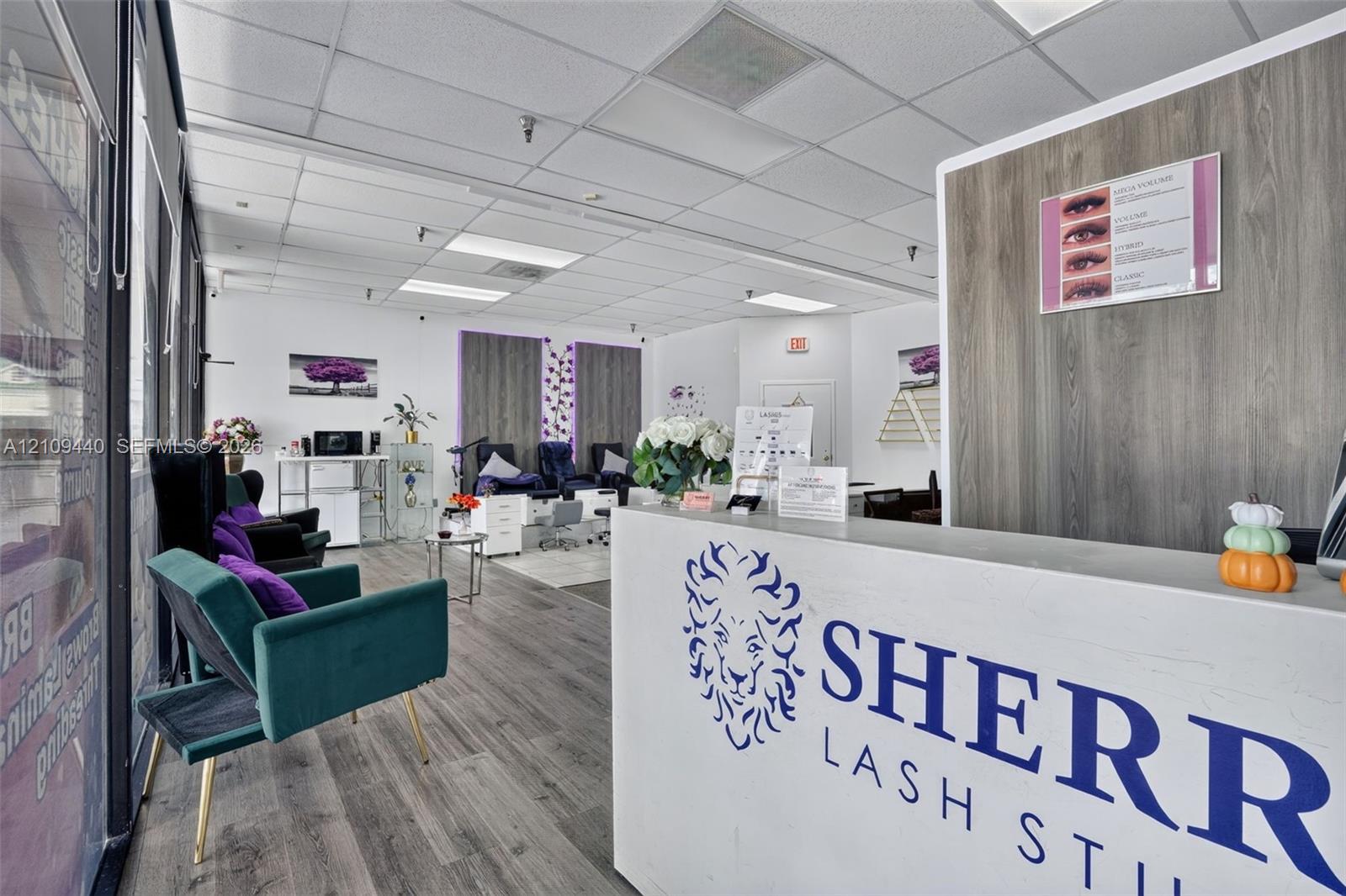 Commercial space featuring wood-finish flooring, drop ceiling with recessed lighting, and built-in service reception desk