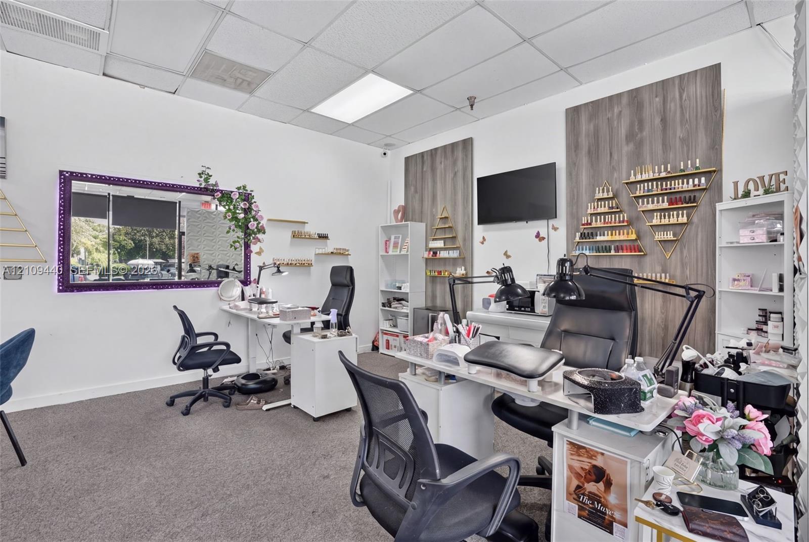 Interior space featuring high-contrast decorative wall paneling, recessed lighting, carpeted flooring, and a large wall-mounted mirror with an ornate frame