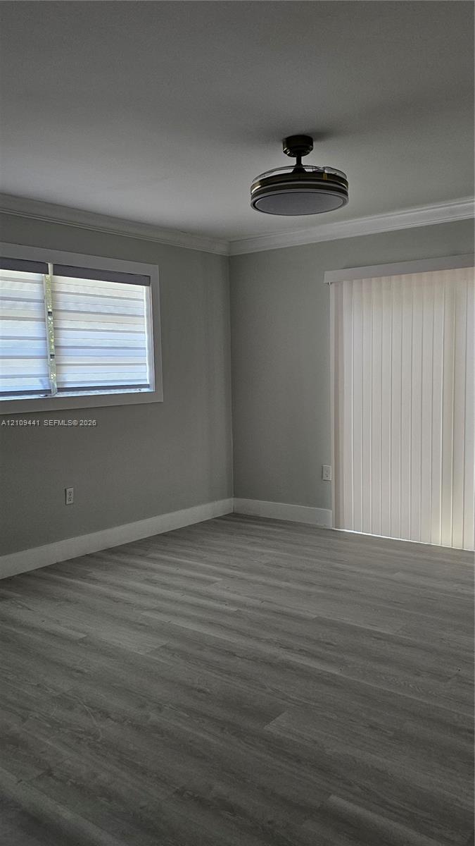 Interior room featuring wood-finish flooring, neutral wall tones, a recessed ceiling fan with integrated lighting, a sliding glass door, and a horizontal window with adjustable blinds
