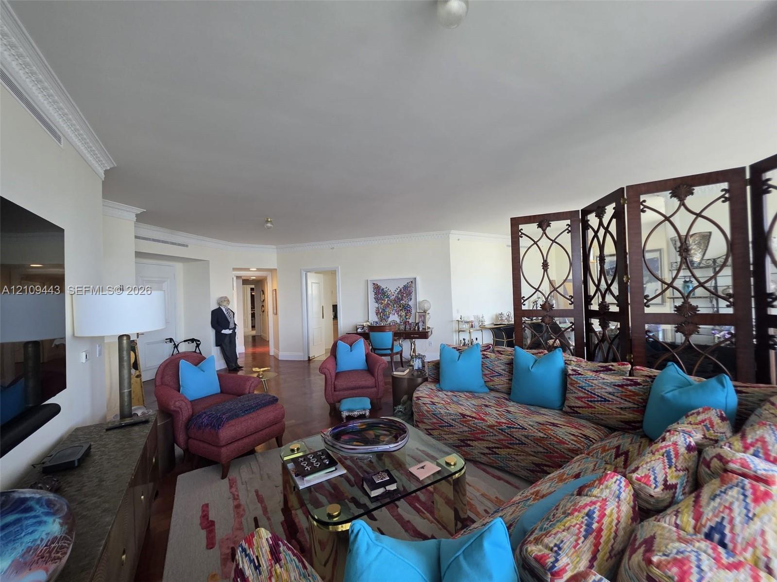 Spacious interior featuring hardwood flooring, intricate crown molding, and recessed lighting