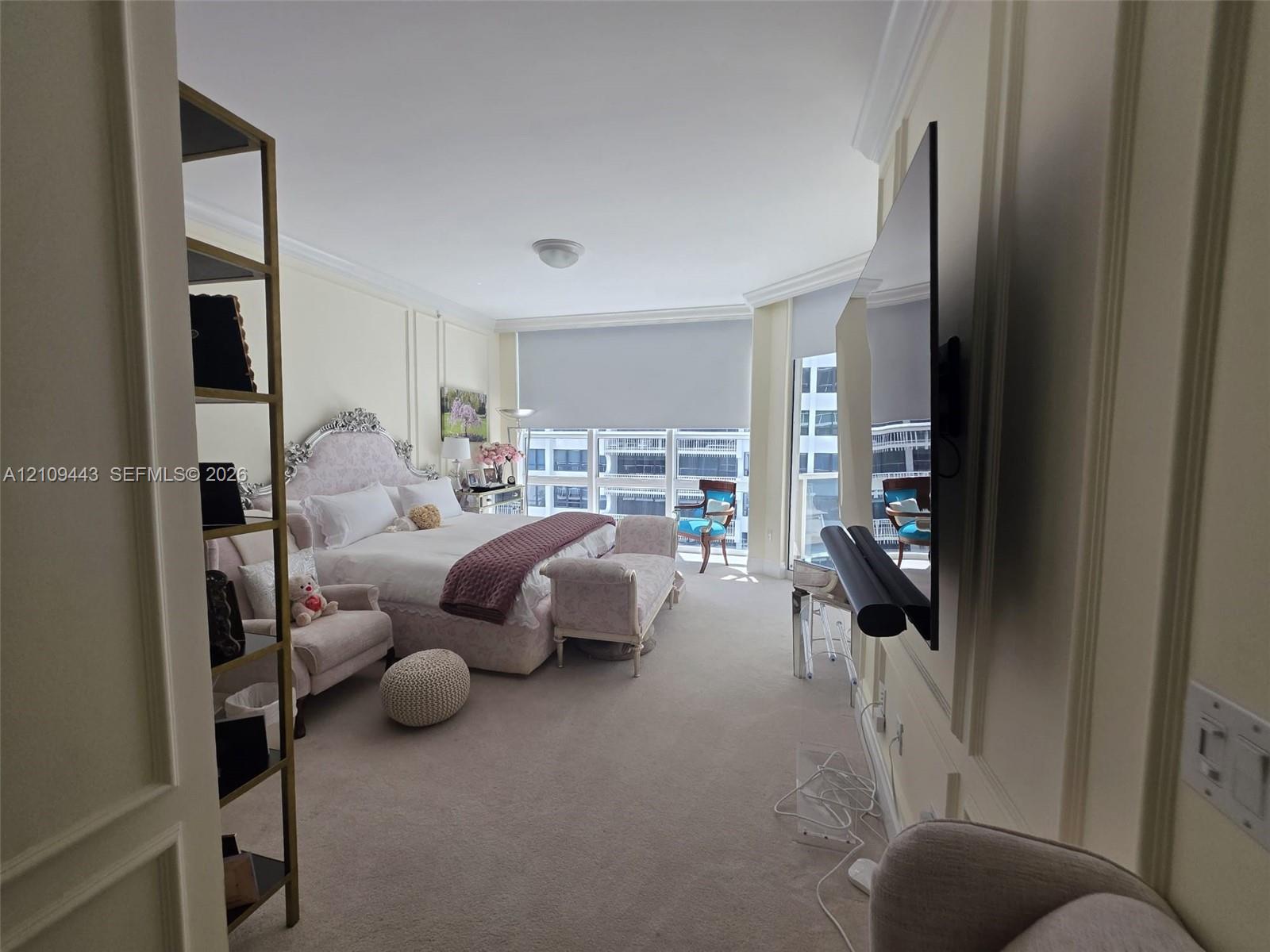Wall paneling detailing, wall-to-wall carpeting, and floor-to-ceiling windows with integrated roller shades