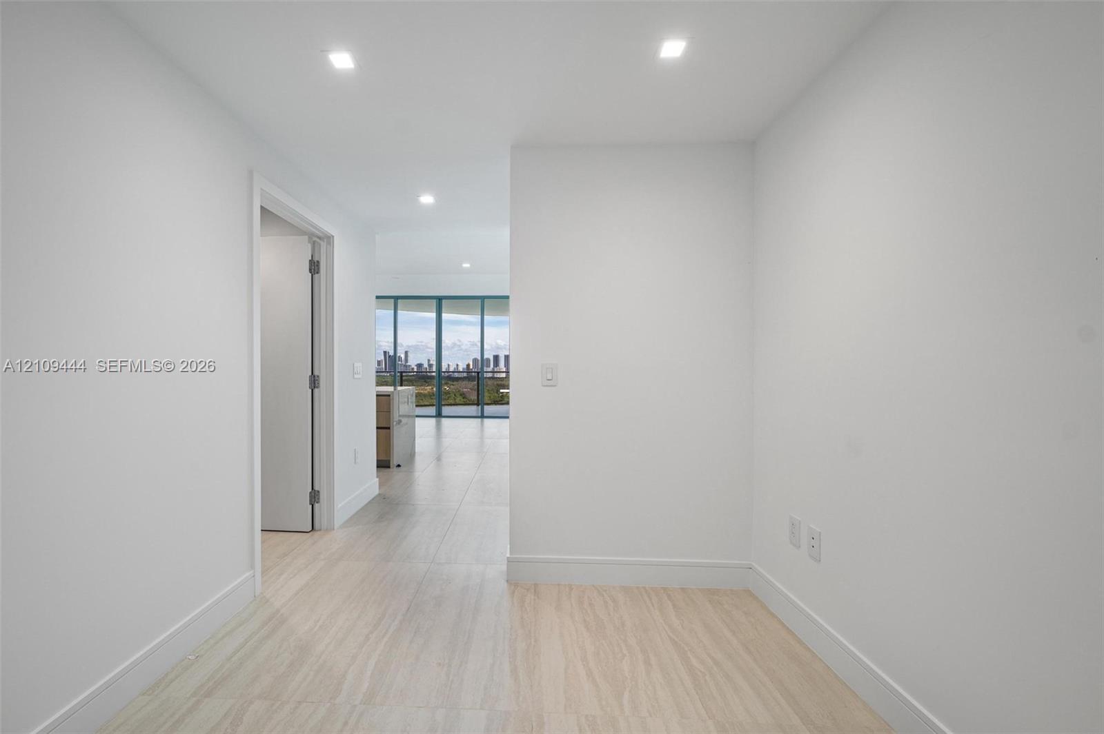 Interior space featuring large-format tile flooring, recessed lighting, and expansive floor-to-ceiling windows