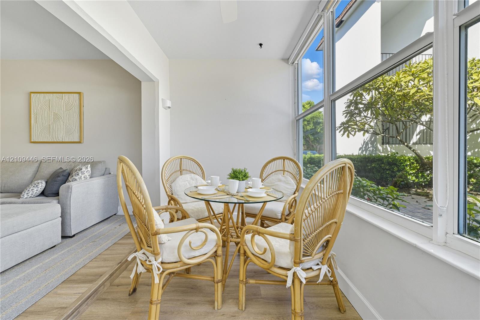 Enclosed sunroom featuring expansive windows and light-toned wood-finish flooring Enclosed sunroom featuring expansive windows and light-toned wood-finish flooring