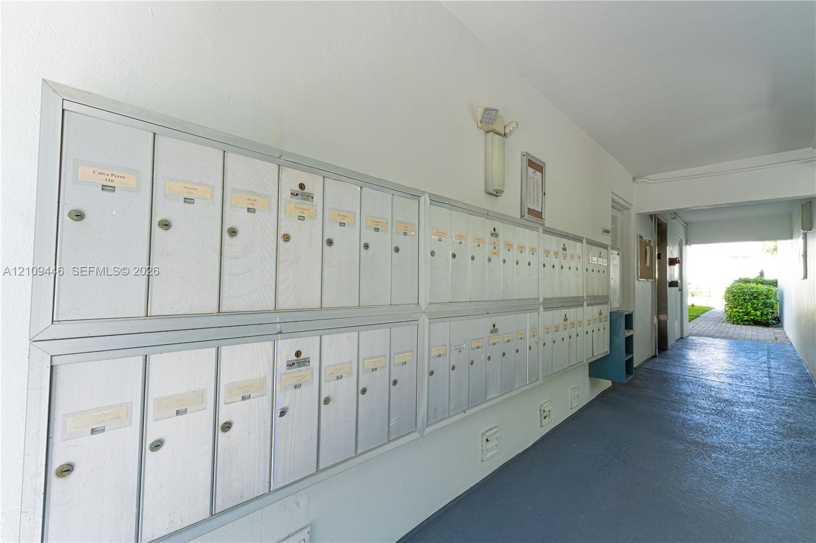 Wall-mounted metallic mailboxes with individual keyed locks and painted concrete flooring