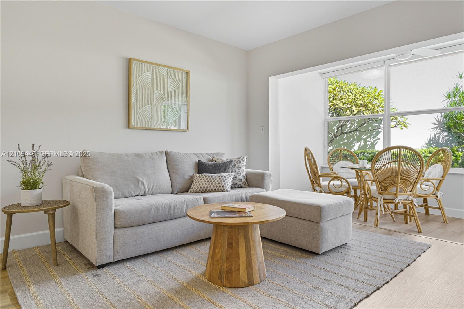 Neutral-toned interior space featuring light-colored wood-finish flooring, a large expansive window, and a recessed alcove Neutral-toned interior space featuring light-colored wood-finish flooring, a large expansive window, and a recessed alcove