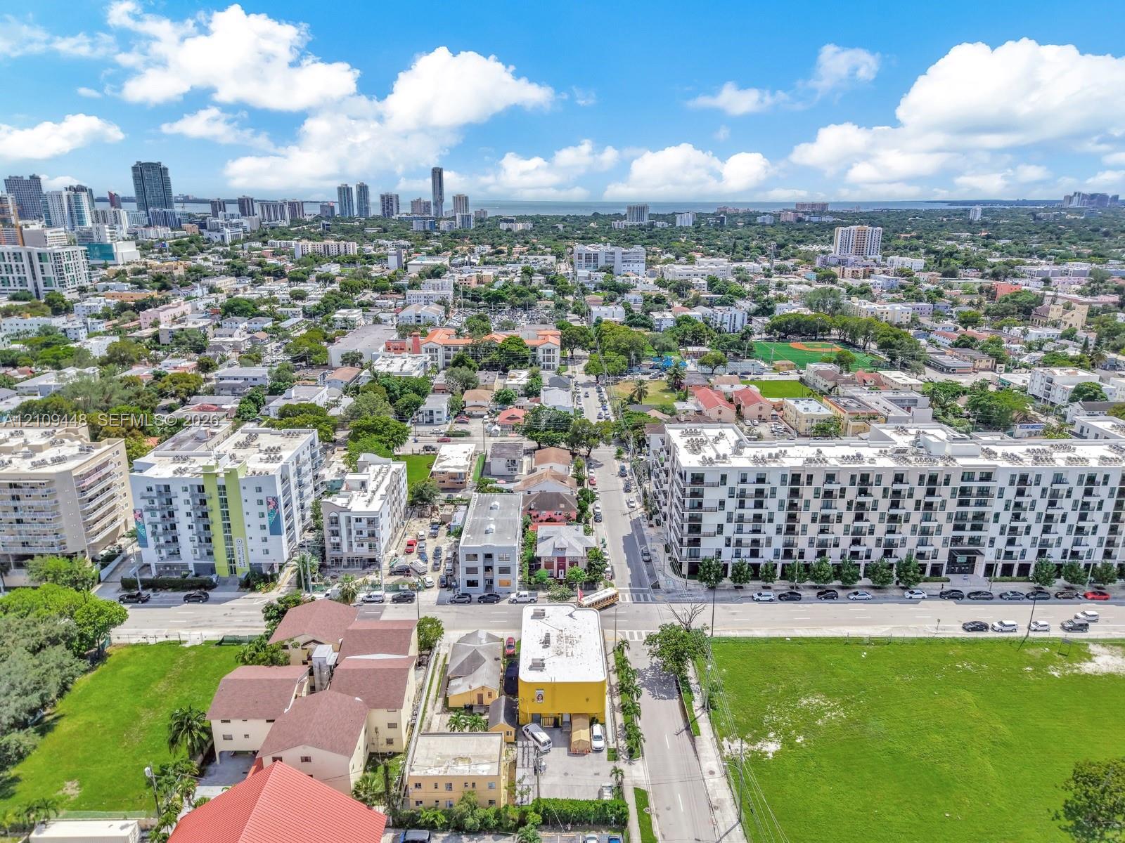 Aerial perspective of the urban landscape featuring mid-rise residential structures, extensive street grid infrastructure, and integrated green spaces