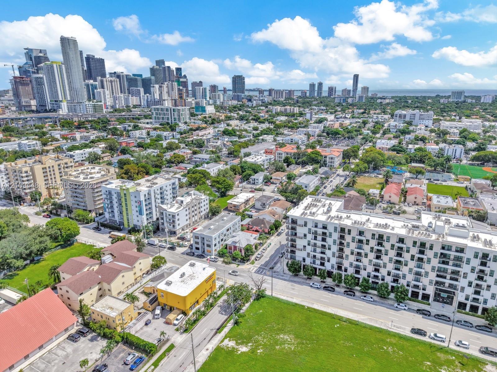 Aerial perspective of the urban landscape featuring multi-story residential buildings, paved street grids, and proximity to the city skyline Aerial perspective of the urban landscape featuring multi-story residential buildings, paved street grids, and proximity to the city skyline