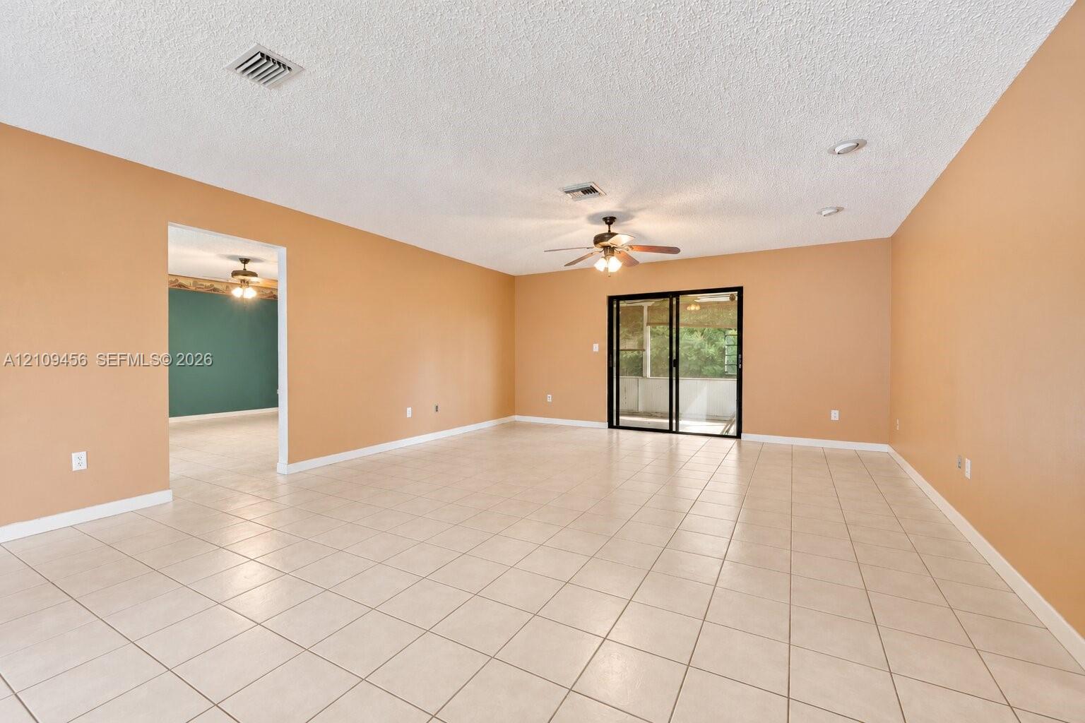 Open-concept space featuring tile flooring, recessed lighting, a ceiling fan, and sliding glass doors