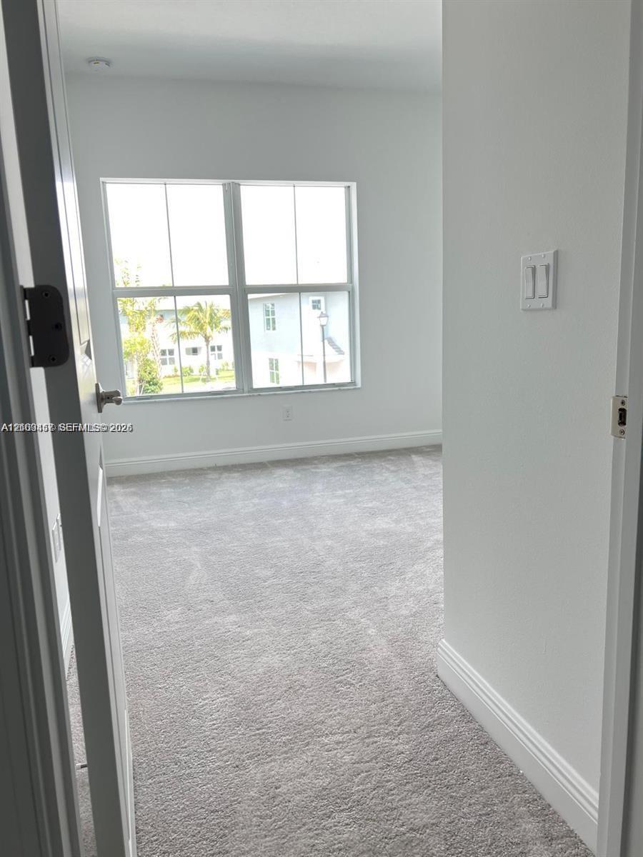 Room interior featuring neutral wall-to-wall carpeting and multi-pane windows