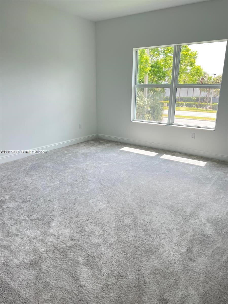 Neutral interior space featuring wall-to-wall carpeting and a large multi-pane window