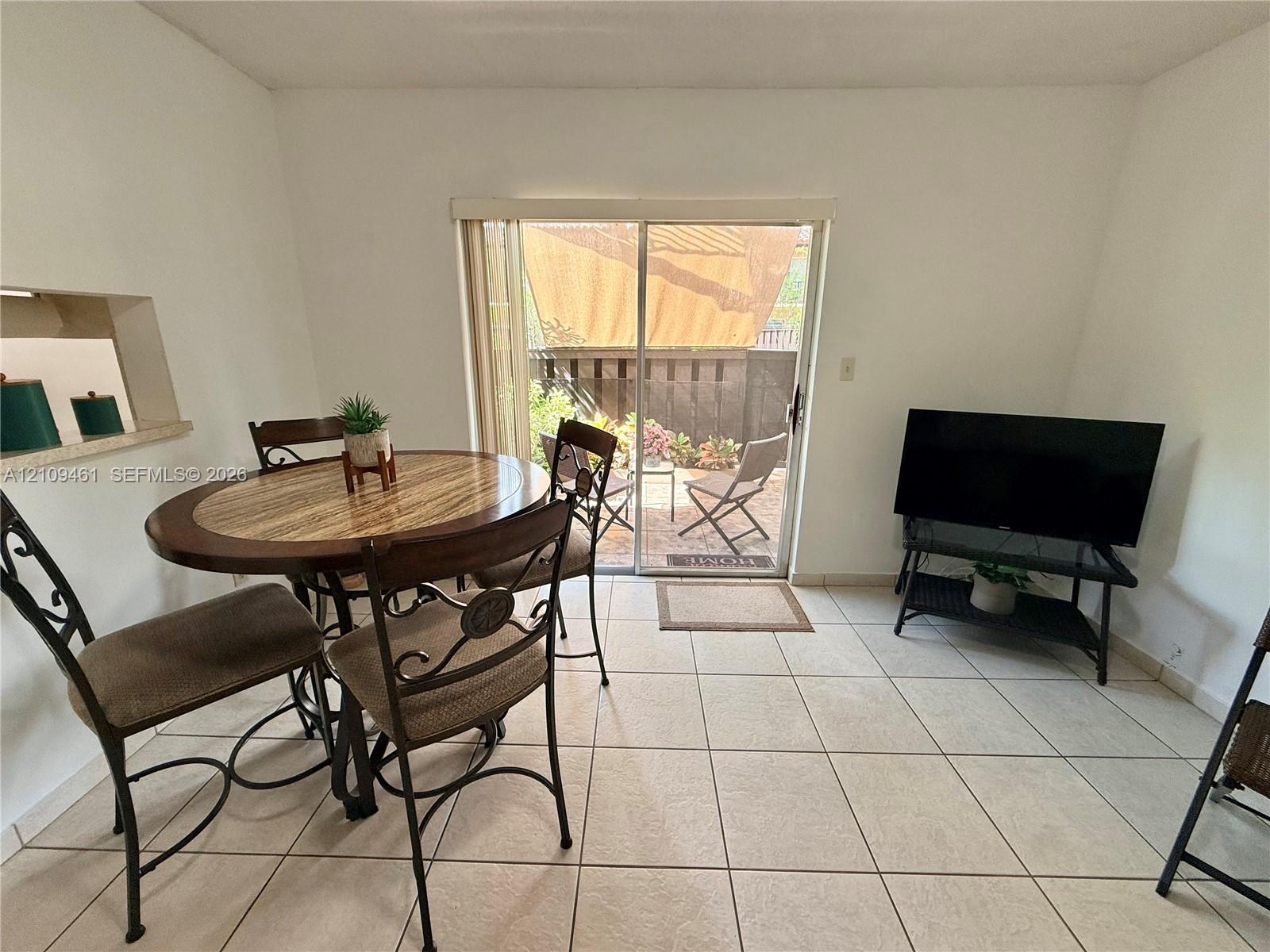 Ceramic tile flooring, aluminum-framed sliding glass door, and interior wall cutout