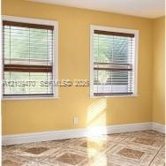 Dual windows with wood-finish blinds and decorative tile flooring Dual windows with wood-finish blinds and decorative tile flooring