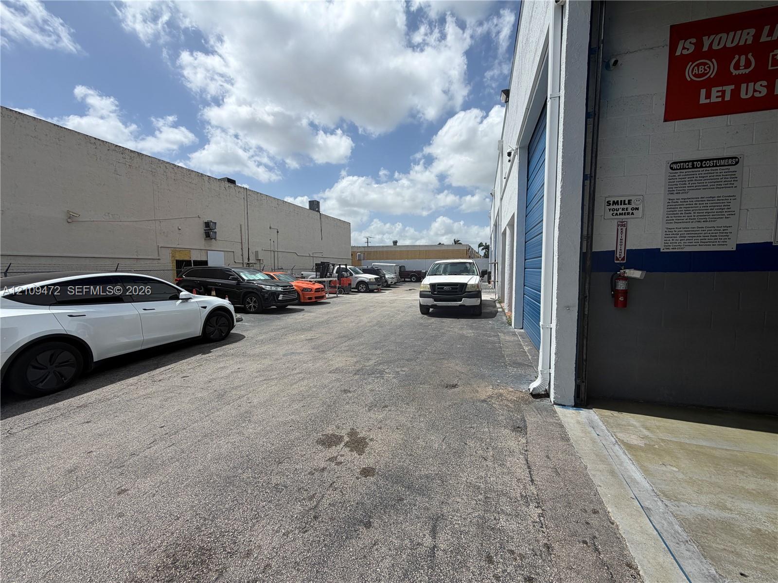 Industrial exterior featuring concrete masonry walls, asphalt paving, and a high-clearance roll-up door