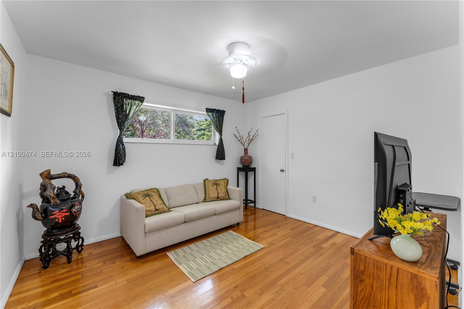 Interior room featuring wood-finish flooring, a horizontal sliding window, and a ceiling-mounted light fixture