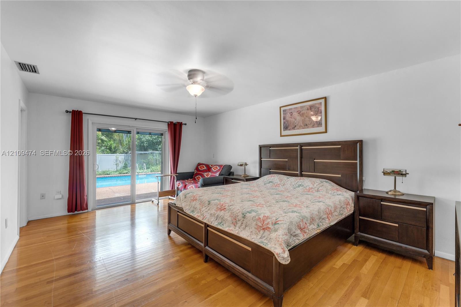 Wood-finish flooring, sliding glass patio door, and ceiling fan with integrated lighting