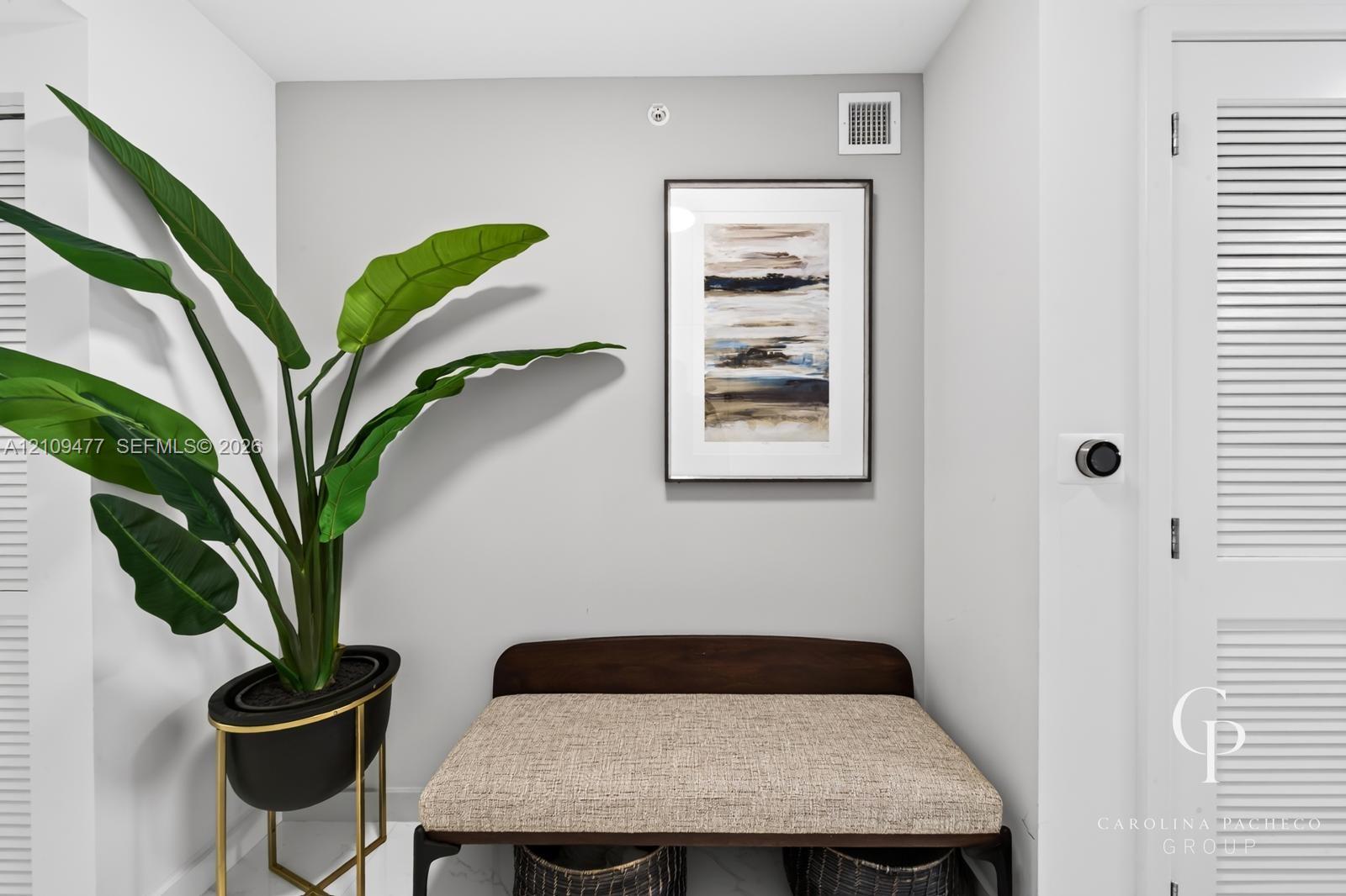 White louvered doors and a wall-mounted programmable thermostat