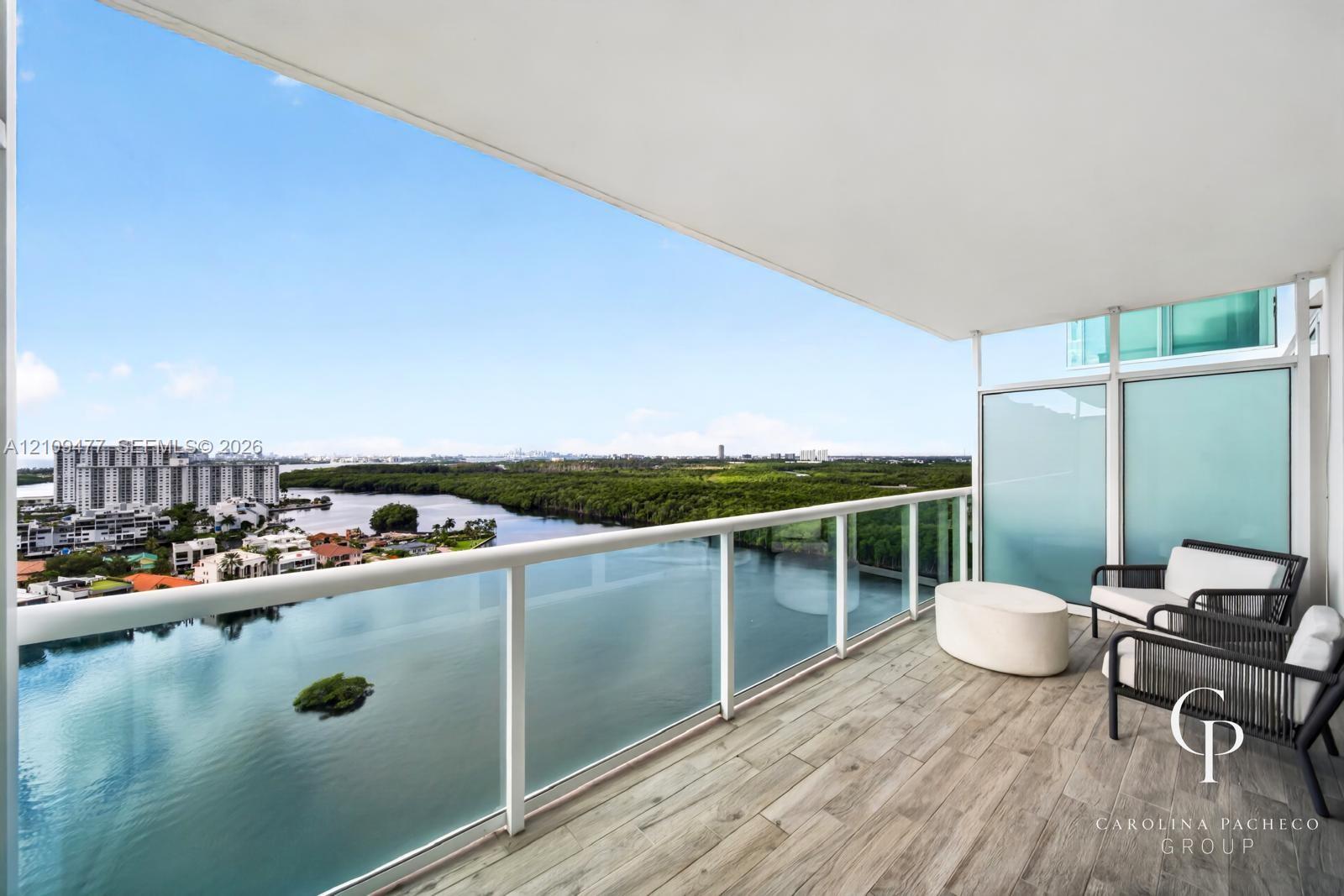 Private balcony featuring wood-finish tile flooring, a glass-panel railing, and frosted privacy partitions