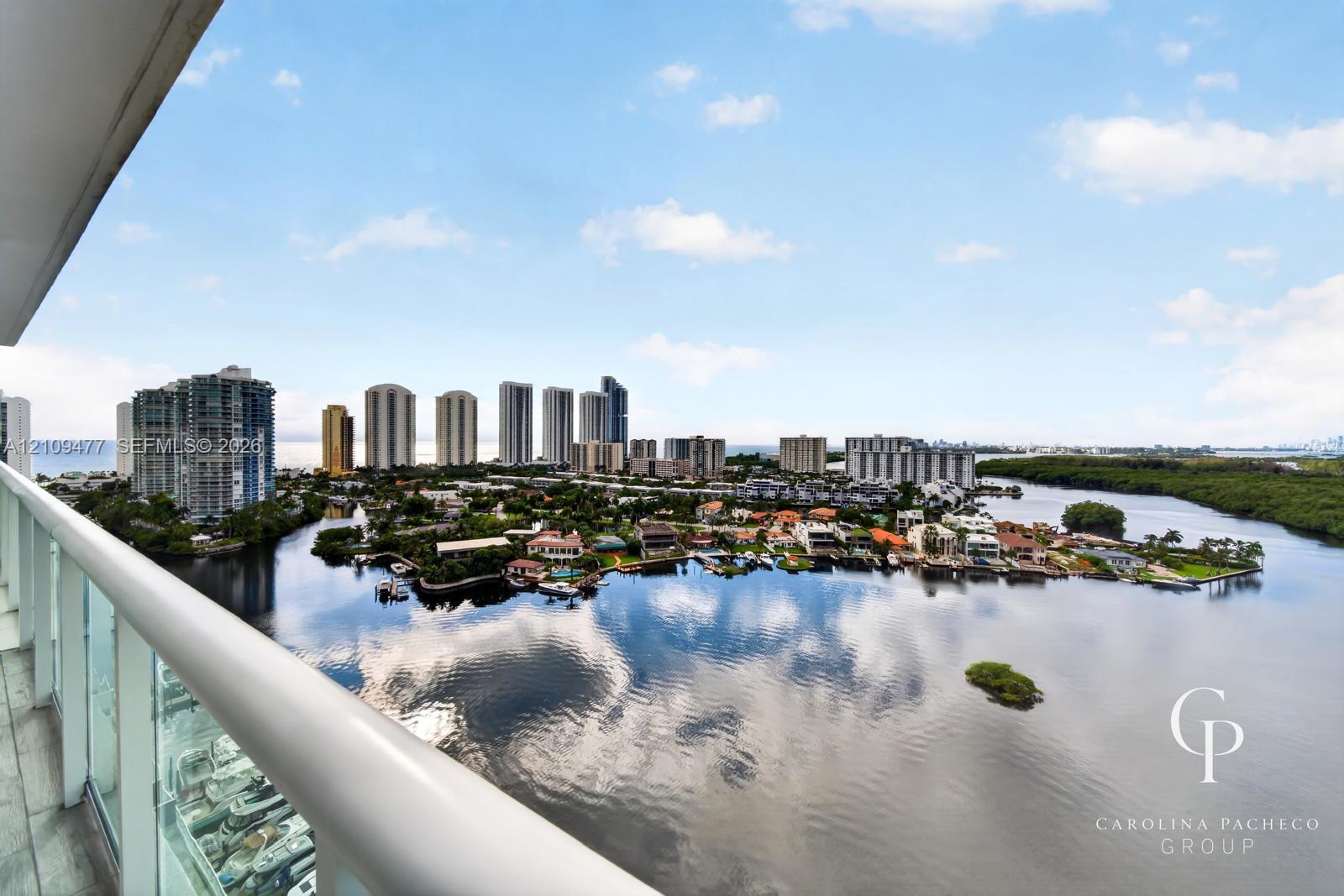 Private balcony featuring glass railings and tile flooring, offering expansive water and cityscape scenery