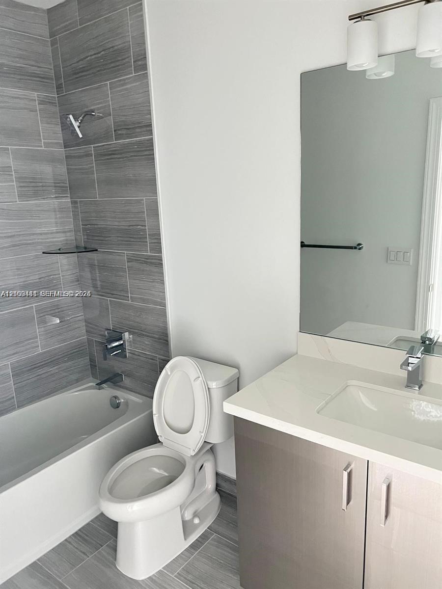 Bathroom featuring a vanity with a light-toned countertop, rectangular undermount sink, and chrome-finish hardware
