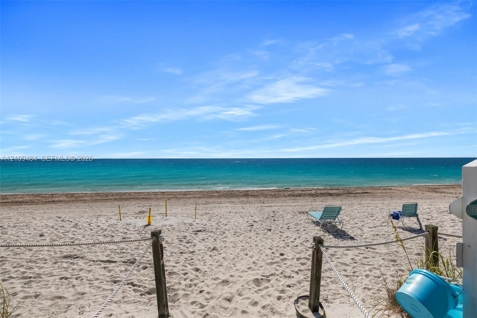 Sandy shoreline featuring wooden post and rope perimeter fencing