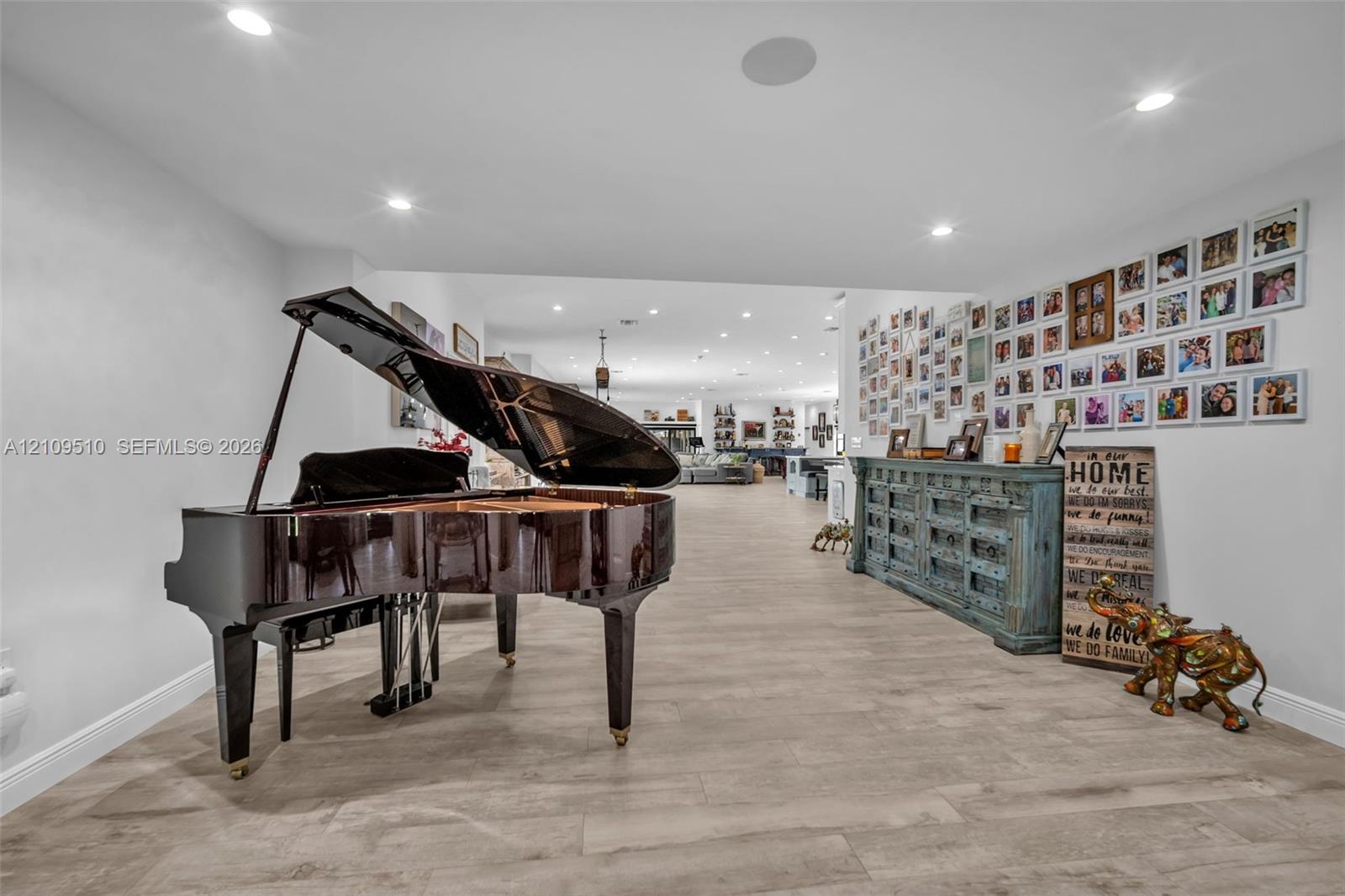 Open-concept interior featuring light-toned wood-finish flooring and recessed ceiling lighting Open-concept interior featuring light-toned wood-finish flooring and recessed ceiling lighting