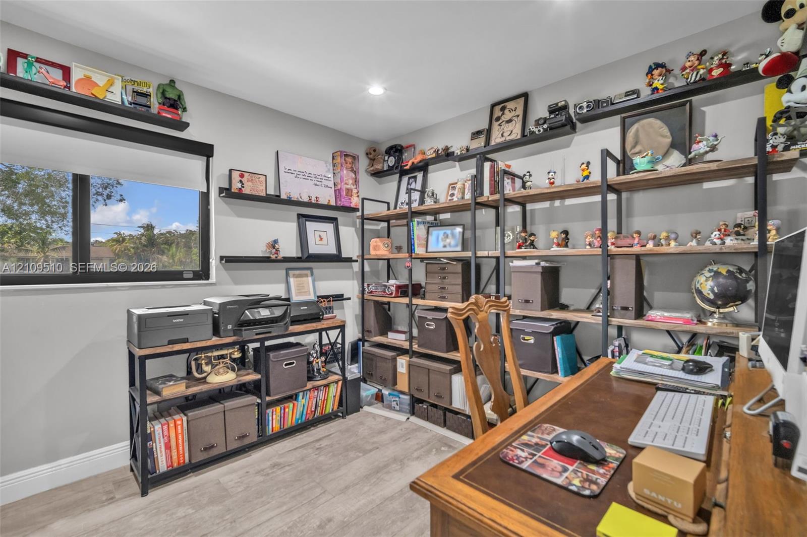 Room featuring wood-finish flooring, recessed lighting, and a large window with black framing