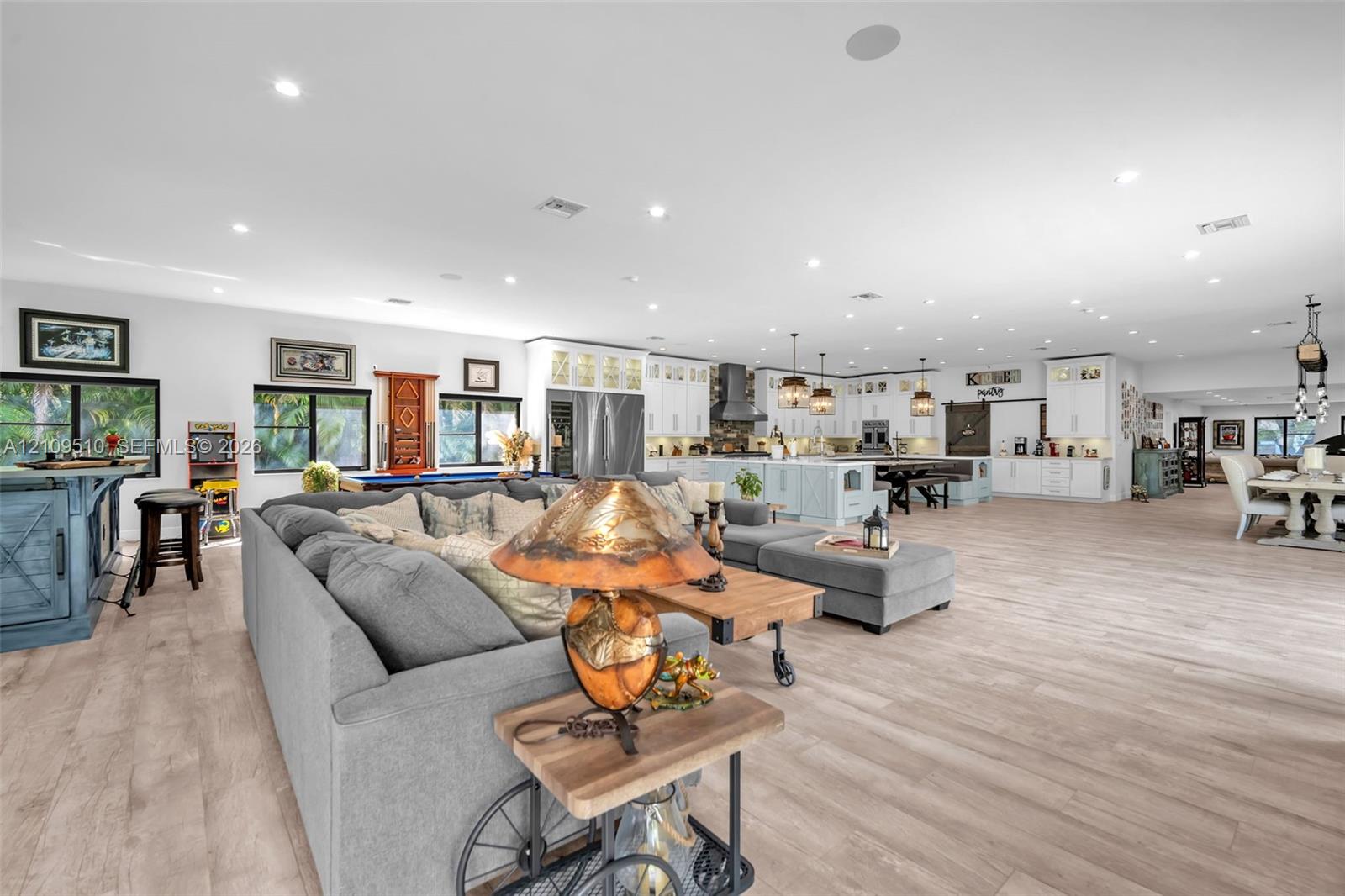 Open-concept interior featuring light wood-finish flooring, recessed lighting, and white cabinetry Open-concept interior featuring light wood-finish flooring, recessed lighting, and white cabinetry