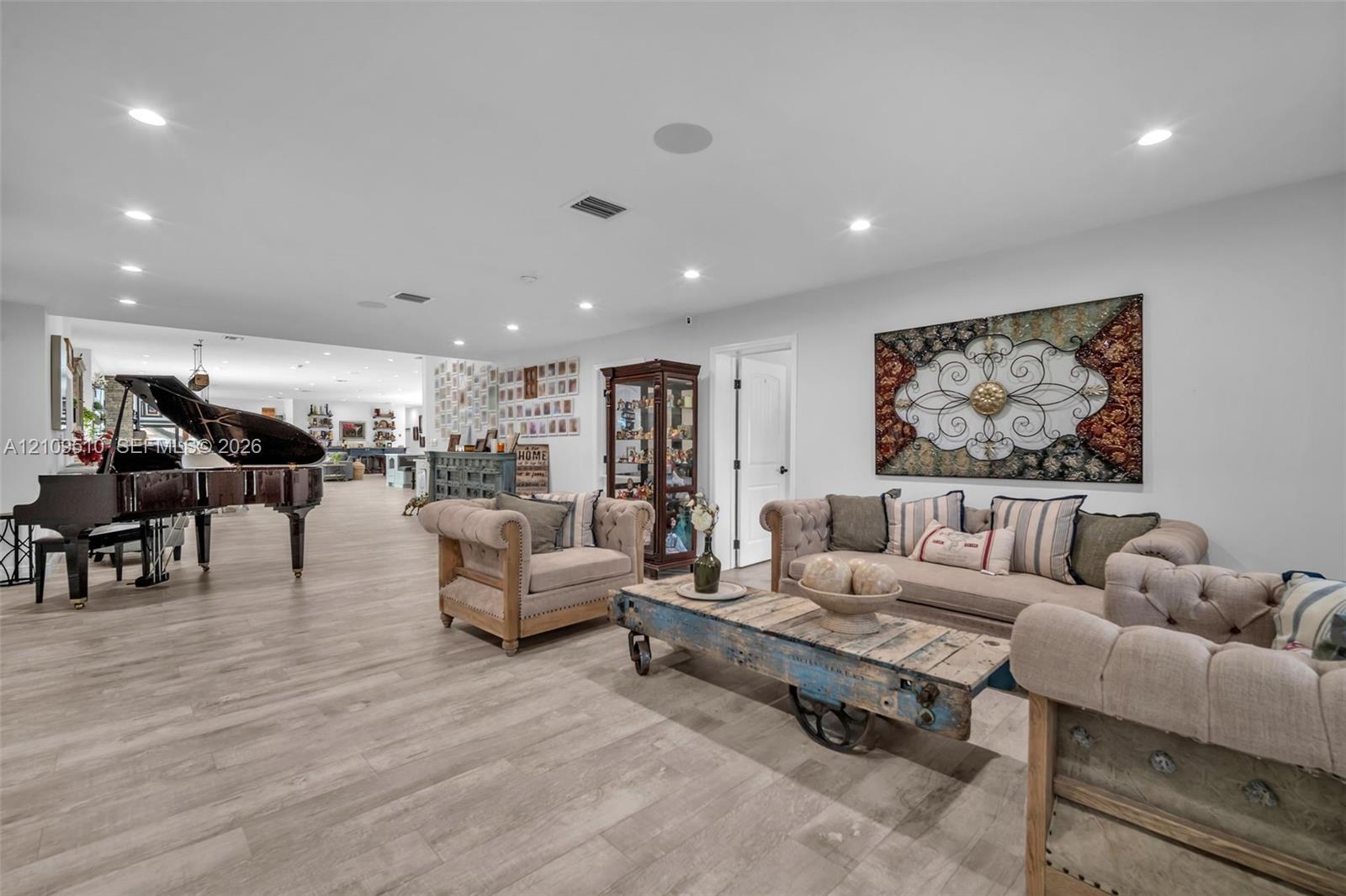 Open-concept interior featuring light-toned wood-finish flooring, recessed lighting, and integrated ceiling speakers Open-concept interior featuring light-toned wood-finish flooring, recessed lighting, and integrated ceiling speakers