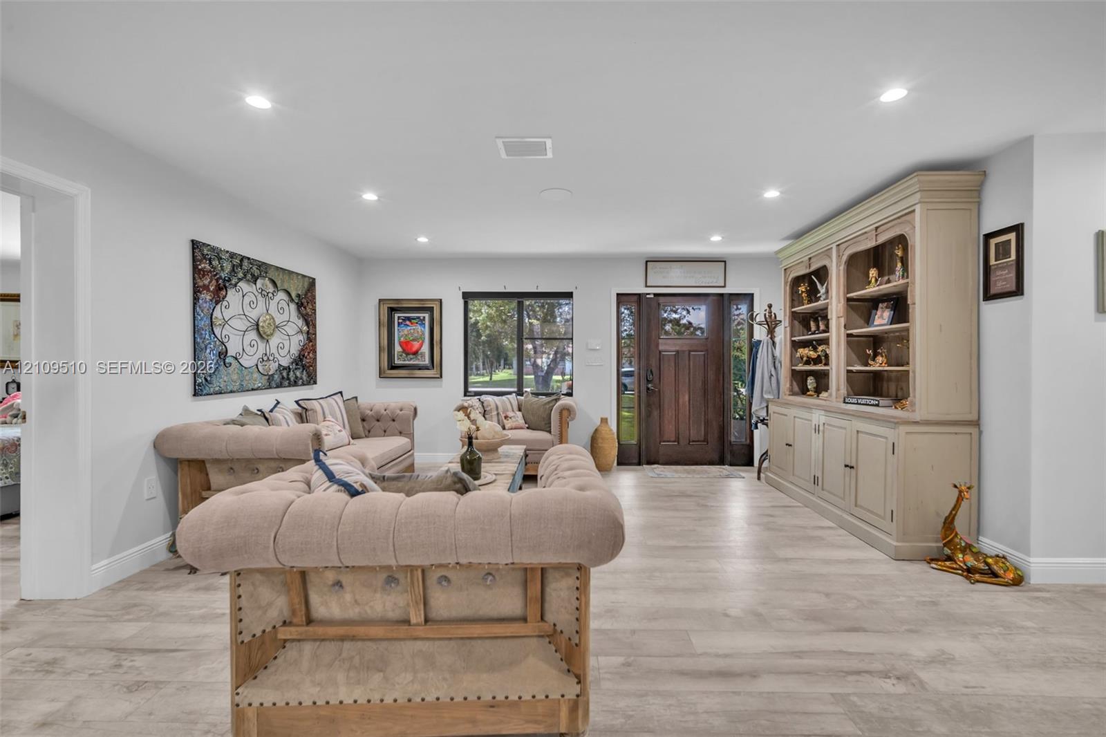 Interior space featuring wood-finish flooring, recessed lighting, and a stained wood front door with sidelights Interior space featuring wood-finish flooring, recessed lighting, and a stained wood front door with sidelights