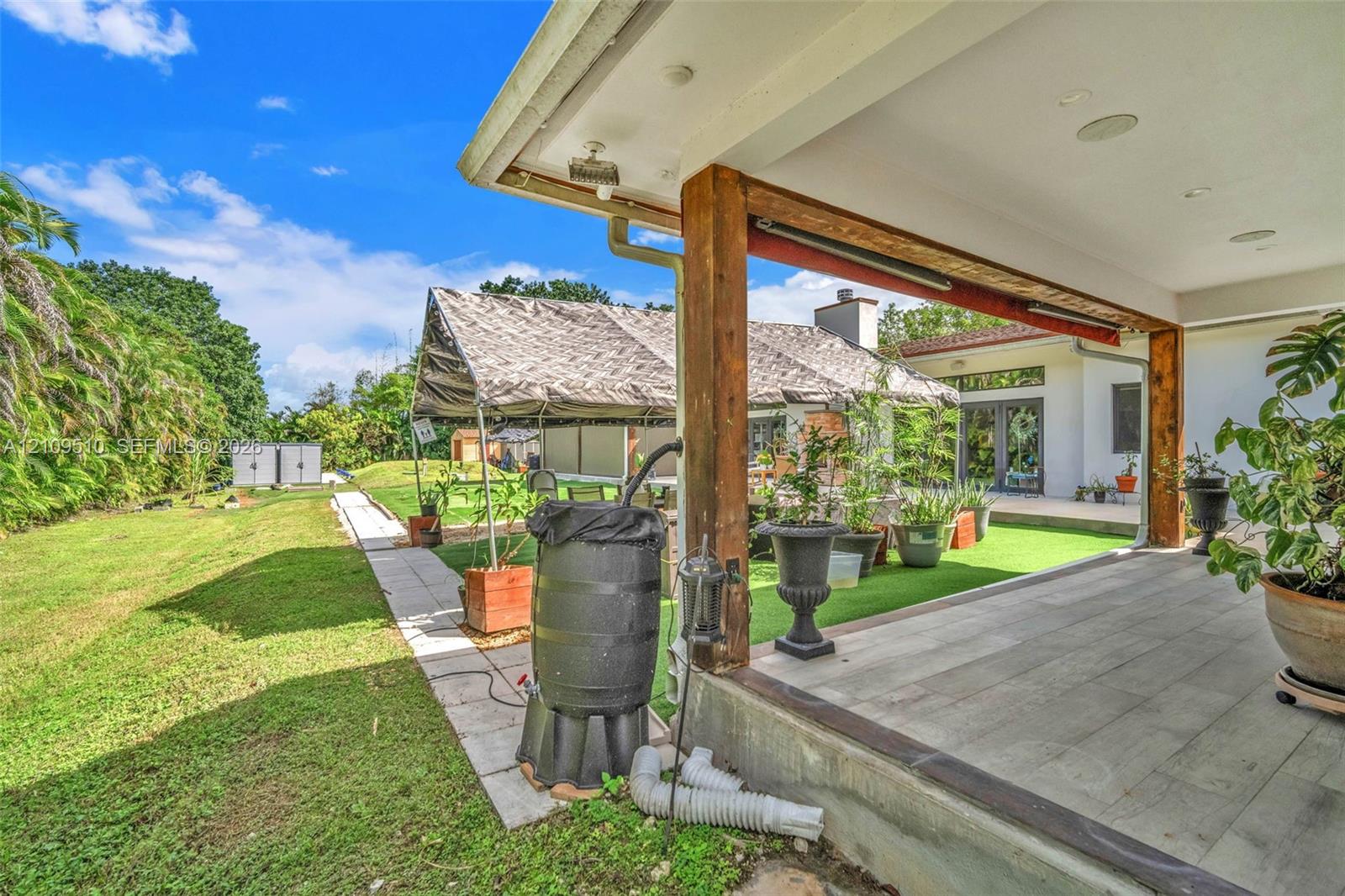 Covered patio featuring wood-finish flooring, exposed wooden support beams, and recessed ceiling lighting