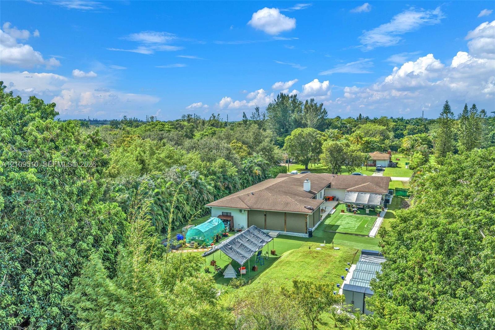 Expansive lot featuring mature trees, a multi-section roofline, and extensive open green space