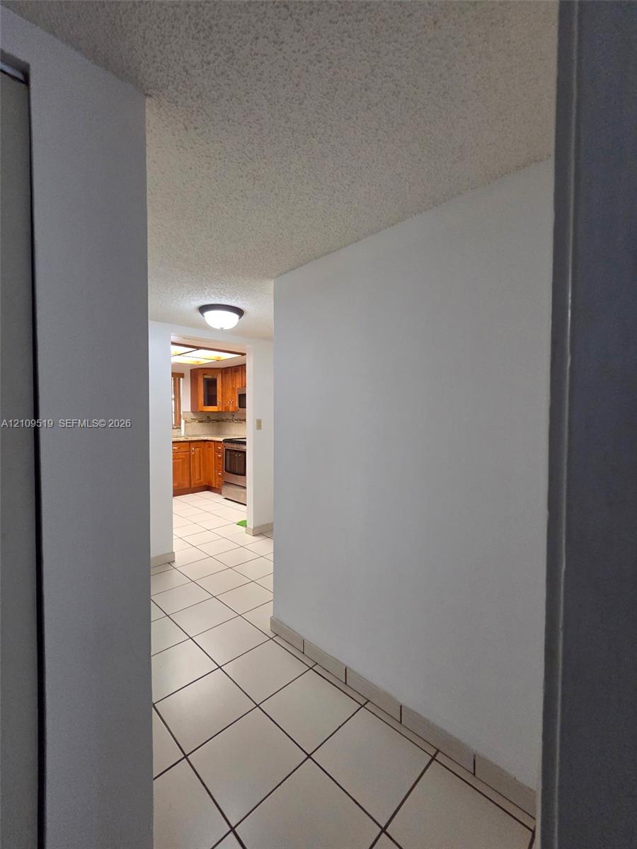 View from hallway to foyer entrance and kitchen