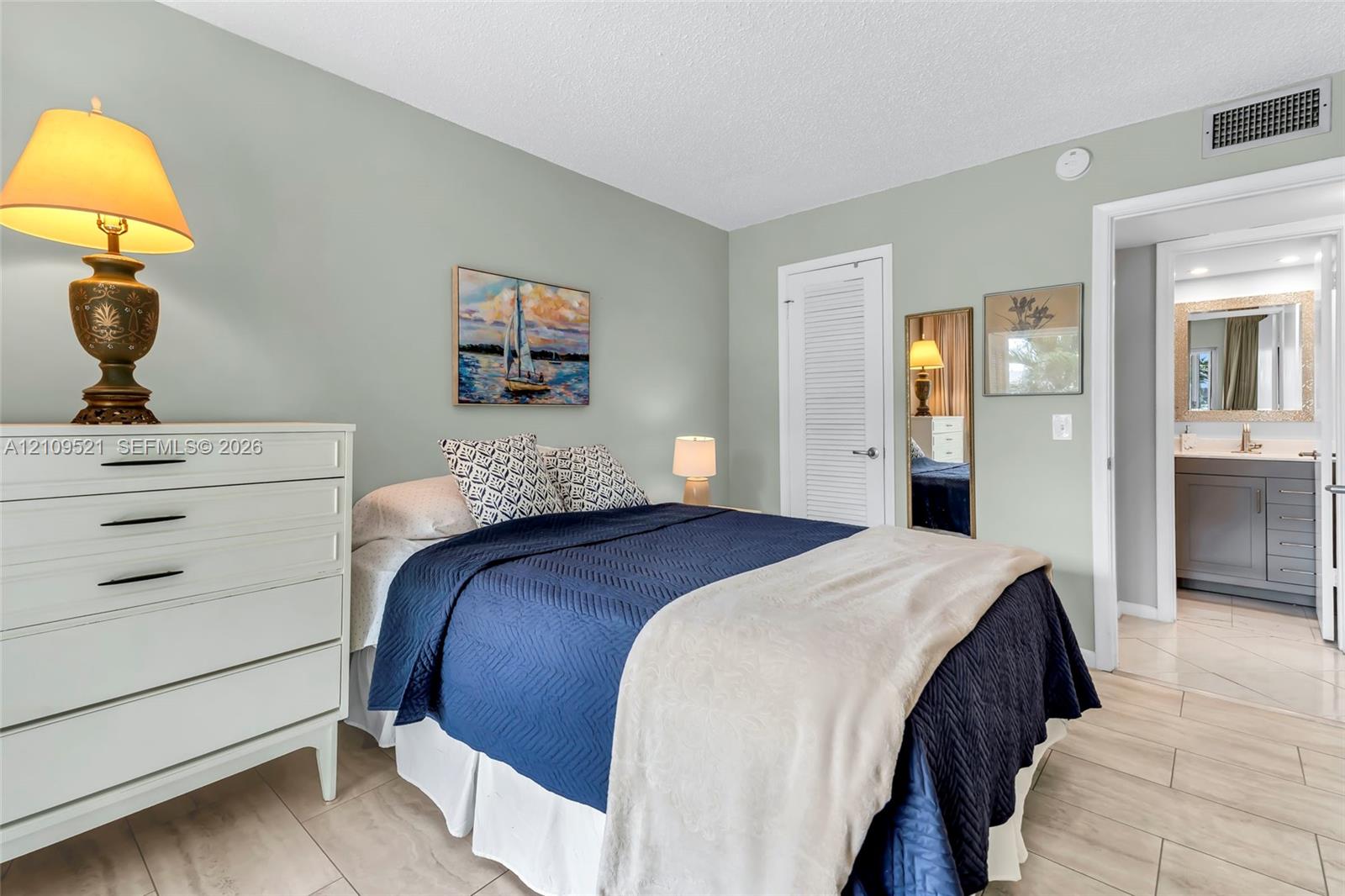 Neutral wall paint, light-toned tile flooring, and a louvered closet door