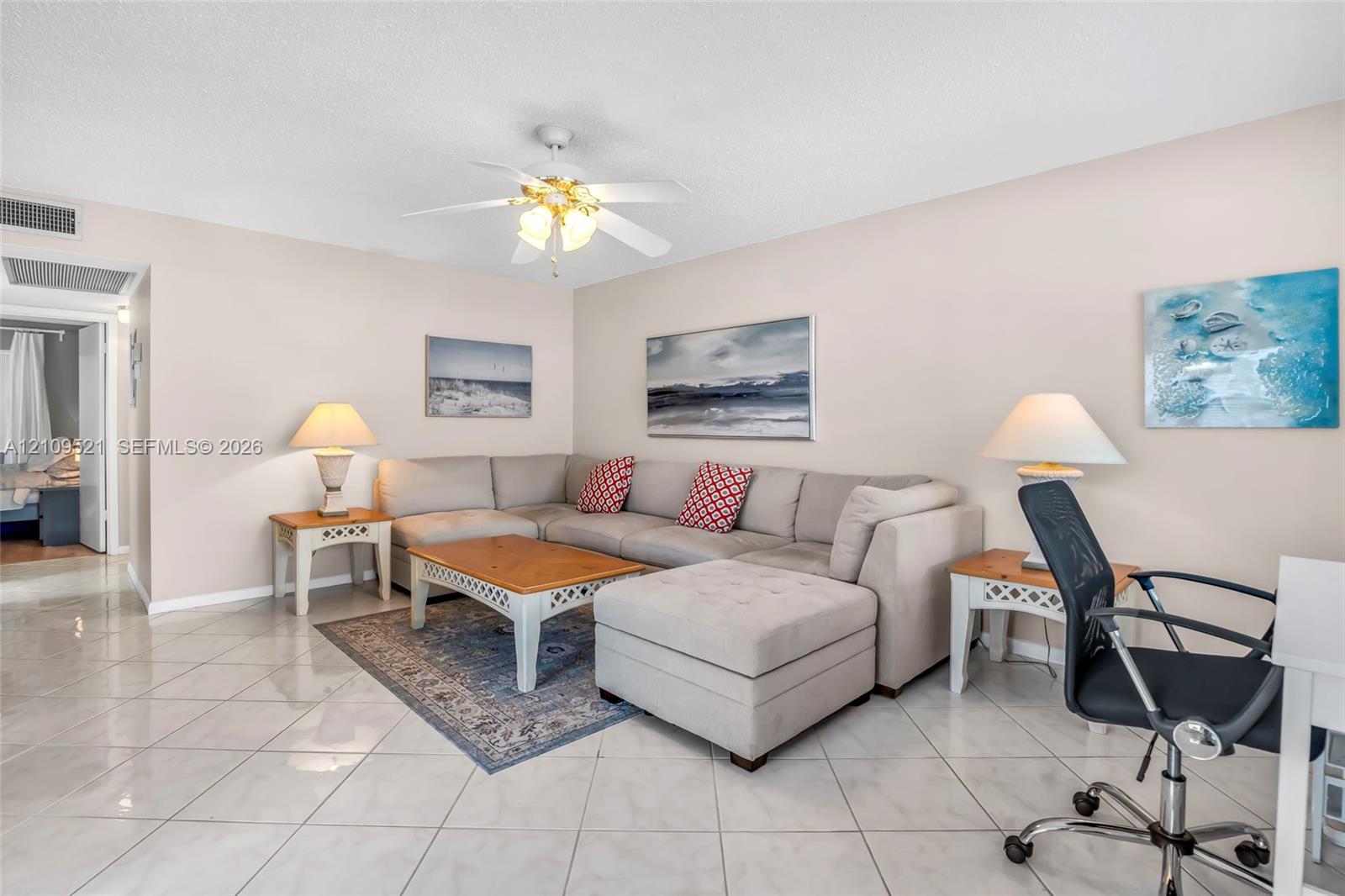 Neutral-toned interior featuring large-format tile flooring and a ceiling-mounted fan with integrated light fixture