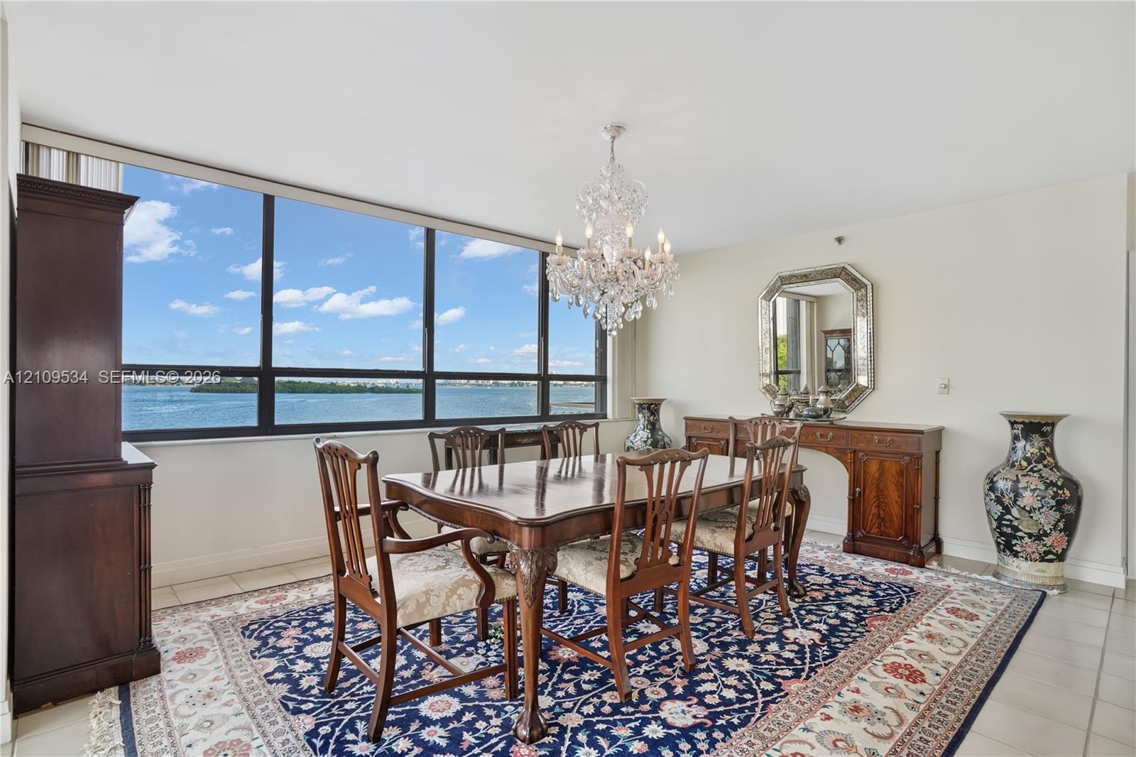 Floor-to-ceiling windows with water scenery, polished tile flooring, and a multi-tiered crystal chandelier Floor-to-ceiling windows with water scenery, polished tile flooring, and a multi-tiered crystal chandelier