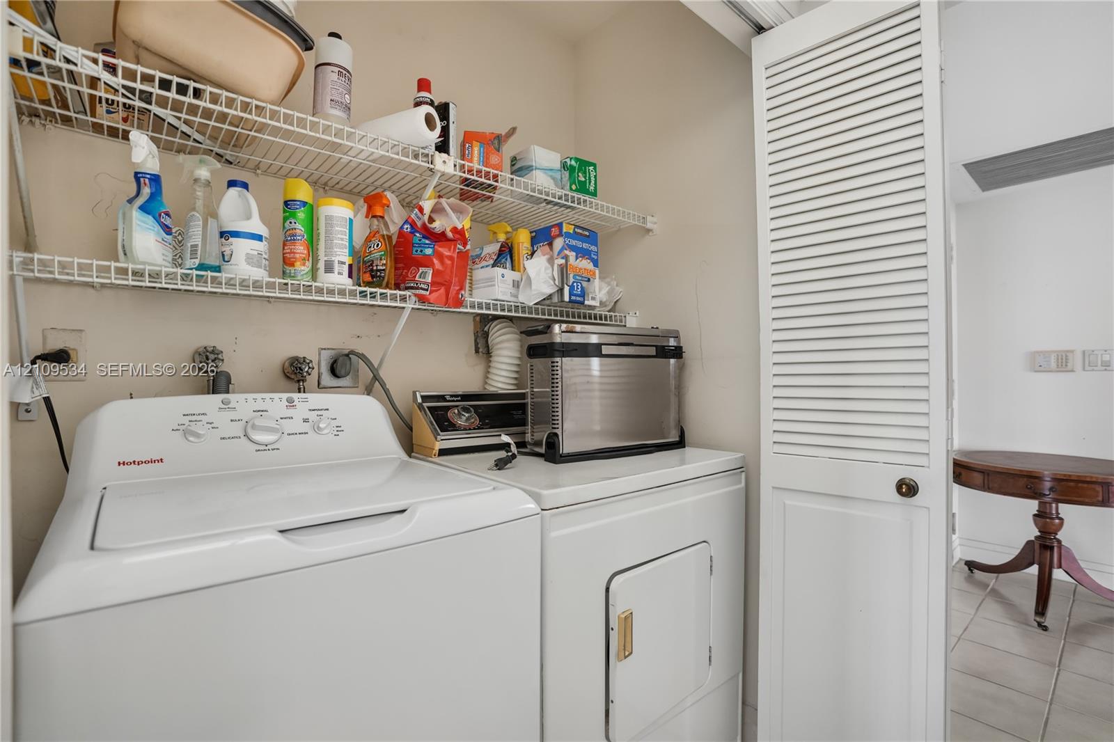 Laundry area featuring white louvered bifold doors and wire shelving