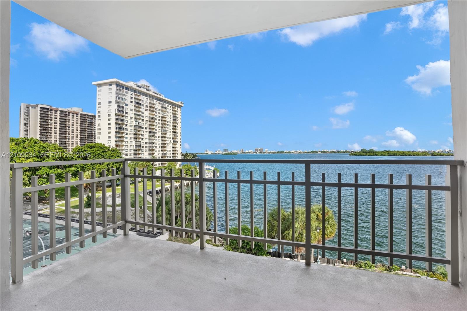 Covered balcony featuring concrete flooring and a metal railing