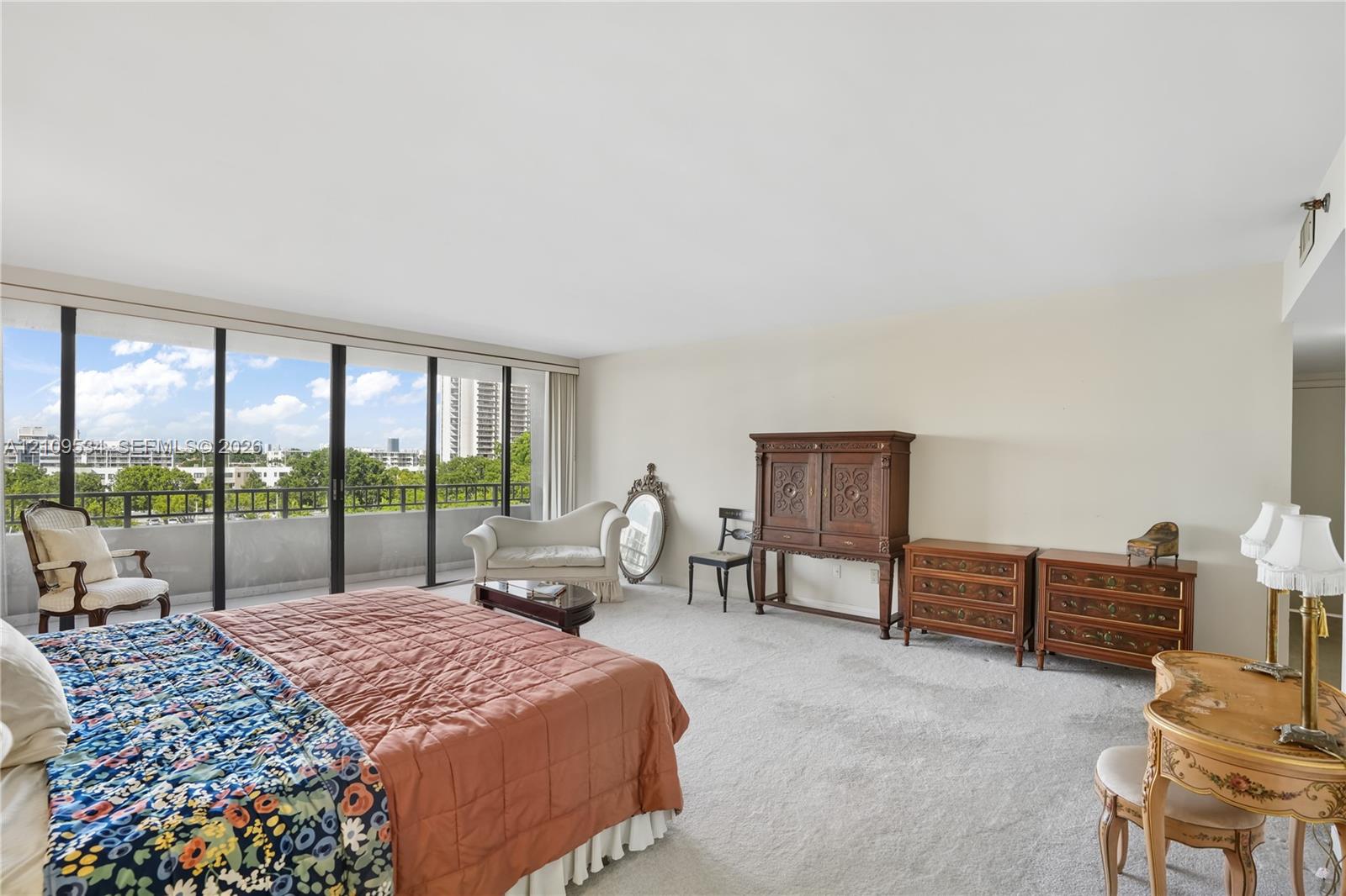 Floor-to-ceiling glass sliding doors with access to an exterior balcony featuring metal railings