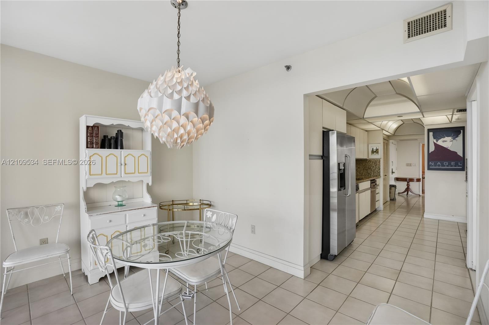 Ceramic tile flooring, stainless steel refrigerator, white built-in hutch, and decorative globe pendant light fixture Ceramic tile flooring, stainless steel refrigerator, white built-in hutch, and decorative globe pendant light fixture