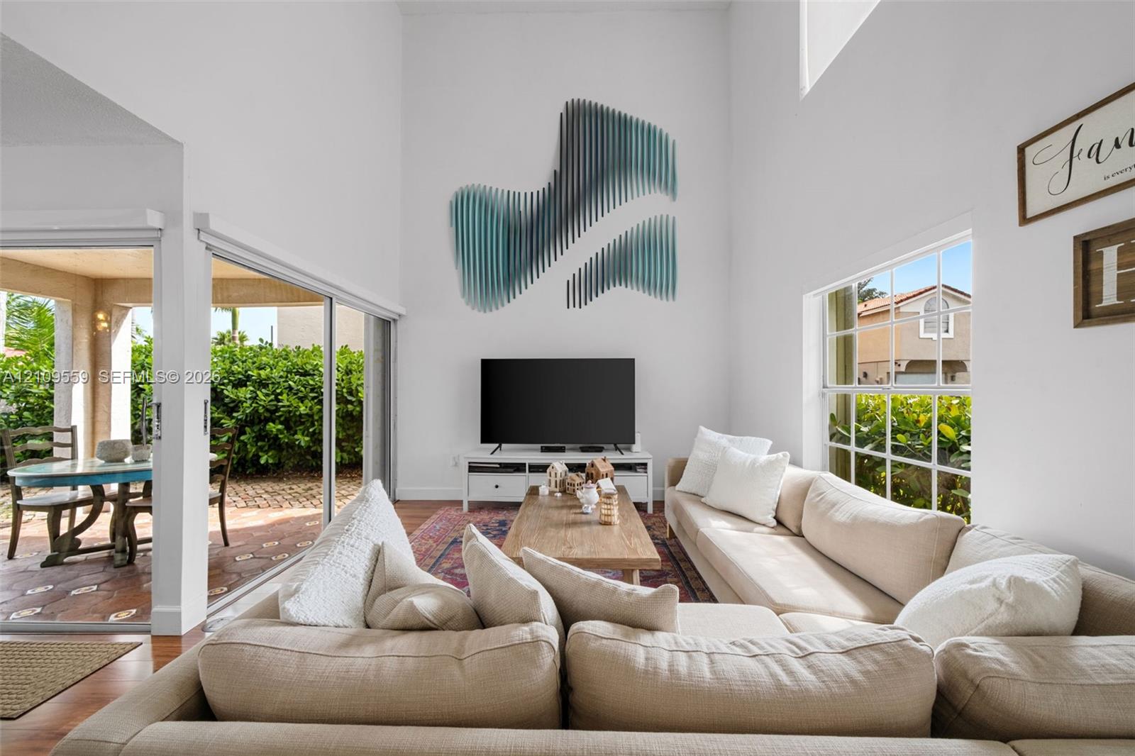 Vaulted ceilings, expansive multi-panel sliding glass doors, and grid-pane windows providing natural light