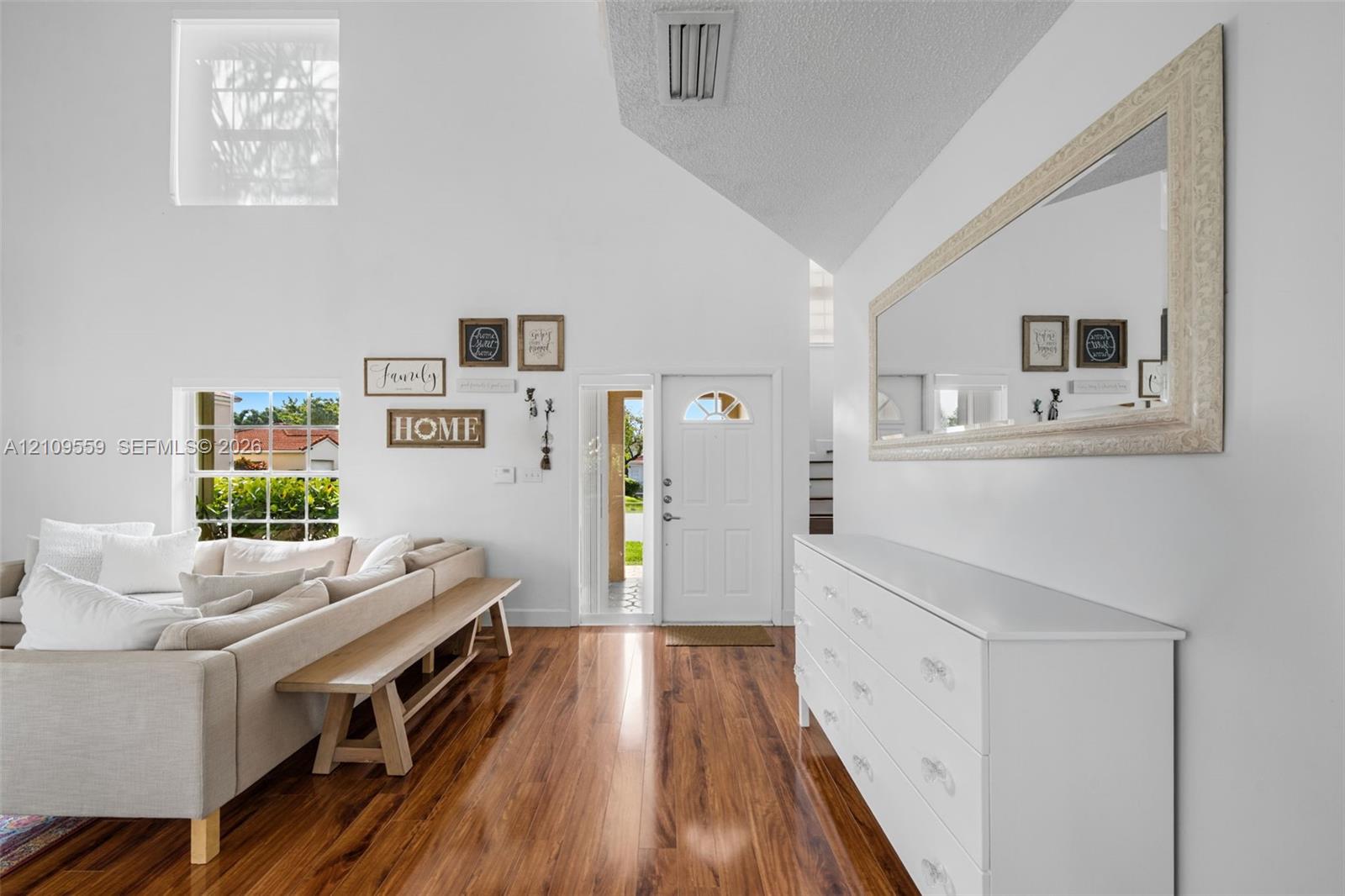 Vaulted ceilings, wood-finish flooring, and natural light from multi-level windows