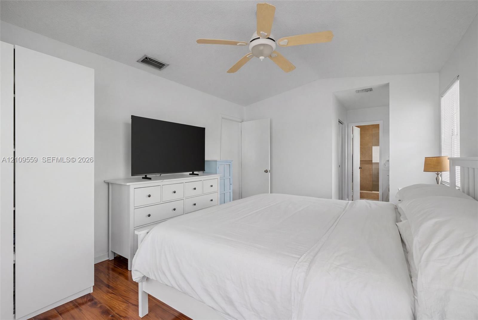 Vaulted ceilings, wood-finish flooring, and a ceiling fan with light fixture